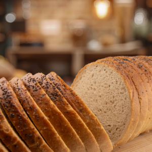 Sliced traditional Polish rye bread with poppy seeds on a wooden board.