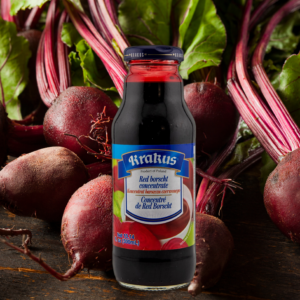 Bottle of Krakus Red Borscht Concentrate in front of fresh beets, showcasing authentic Polish packaging.