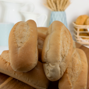 Classic white bread hoagie rolls in a pack of 6, stacked on a wooden surface.